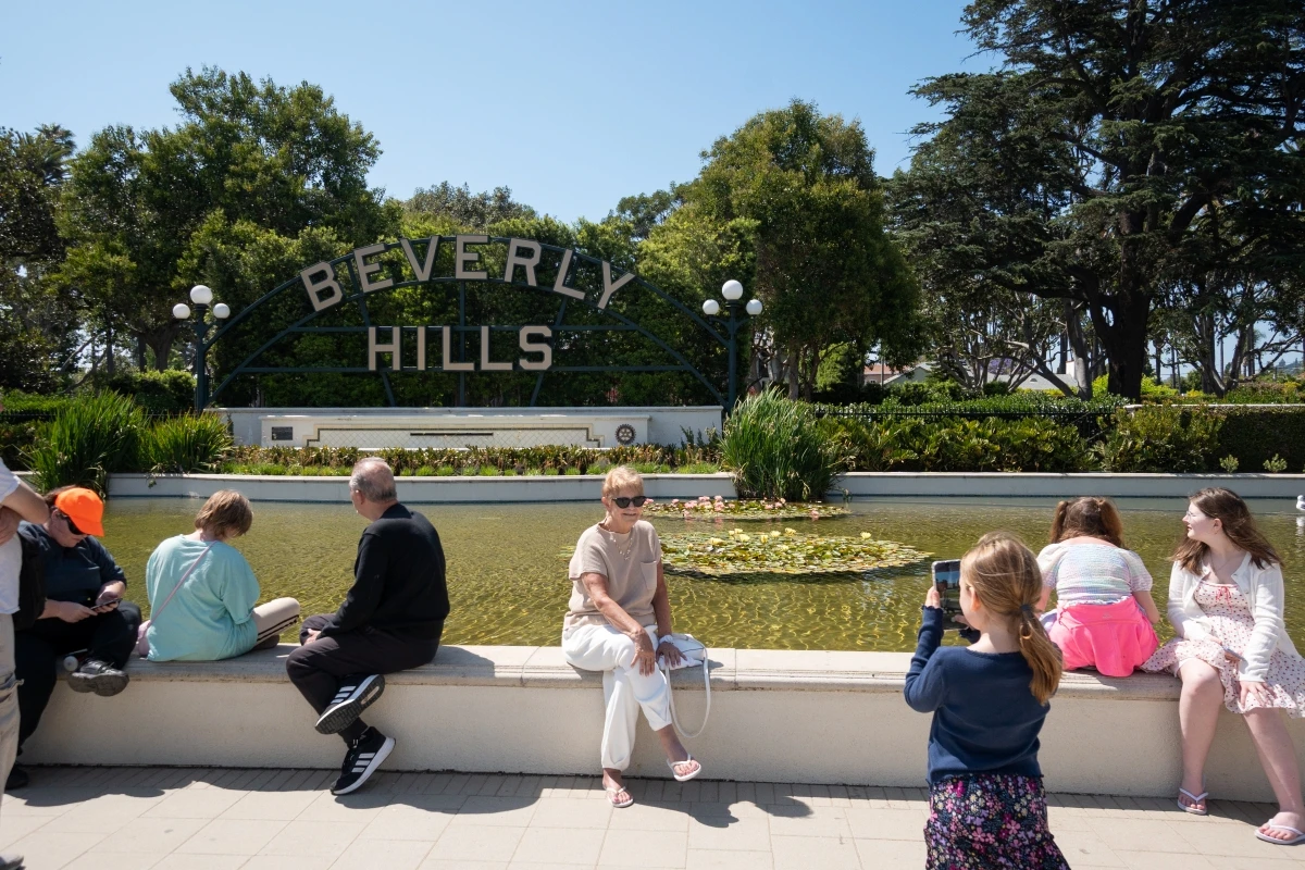 Beverly Hills sign at Gardens Park with tourists and landscaped grounds